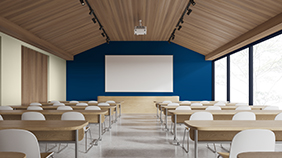 Schreibtische und weiße Stühle vor einer blauen Wand