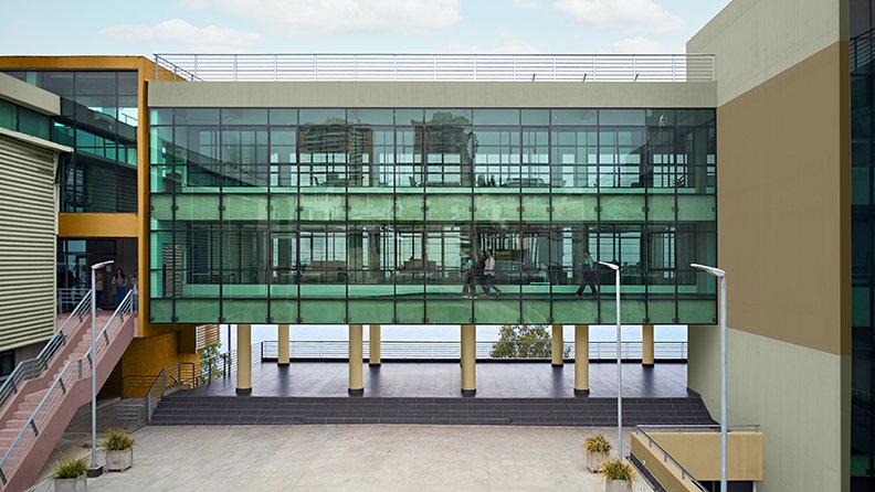 Schulgebäude mit rosa Treppe und grüner Fassade