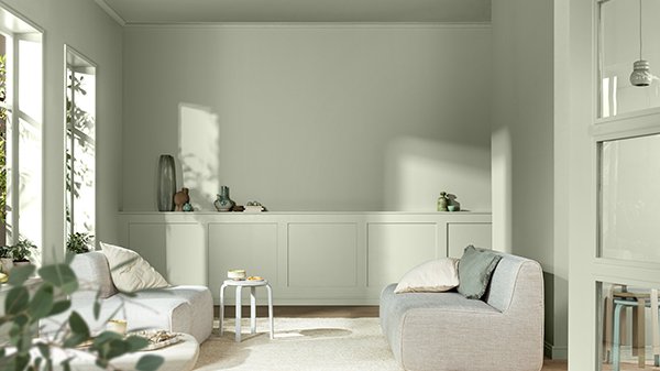 Ein Wohnzimmer mit Wänden und Möbeln in sanftem Grün gestrichen