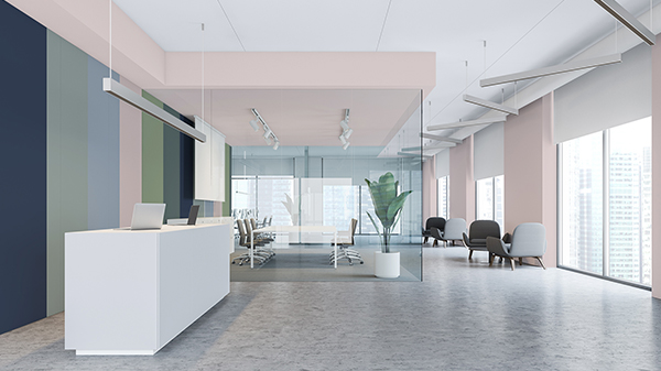 Ein Büro mit einer Rezeption und einem Besprechungsbereich. Eine Wand ist mit verschiedenfarbigen Streifen gestrichen, während die Decke und die gegenüberliegende Wand in Rosa gestrichen sind.