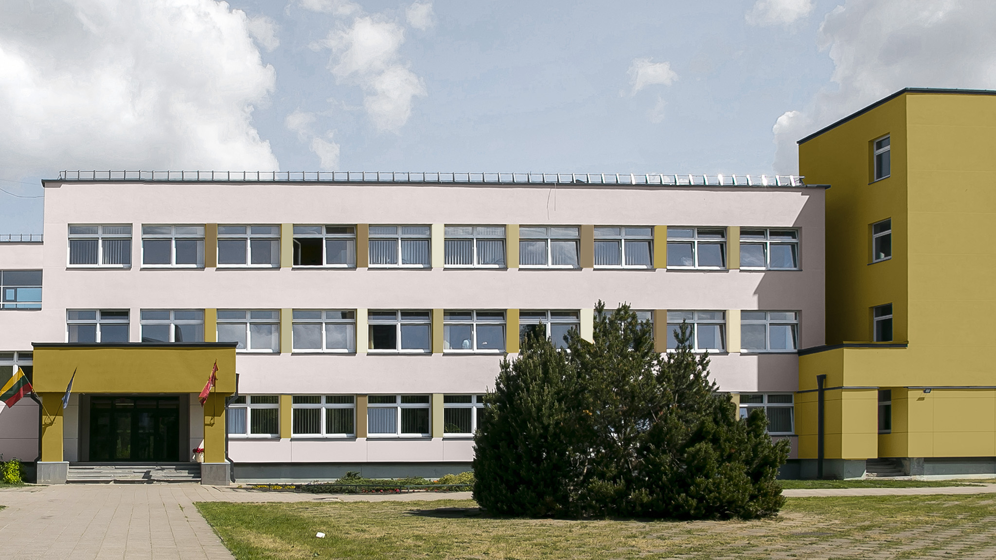 Ein Schulgebäude mit Außenwänden in sanftem Rosa und ockerfarbenen Akzenten 