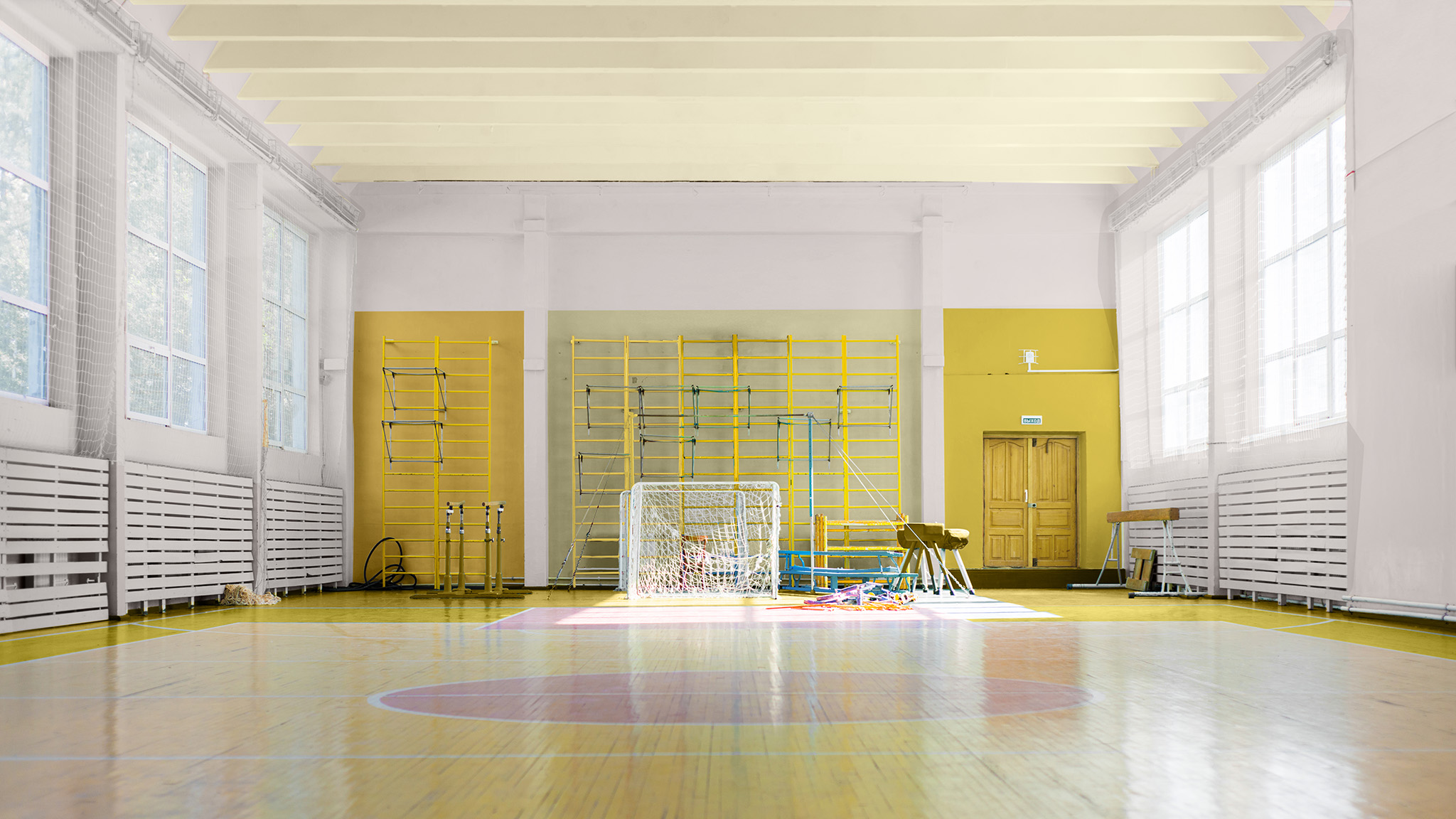 Eine Sporthalle mit Wänden in sanftem Rosa. Die Farbkombination der hinteren Wand sorgt für eine optische Wandaufteilung.