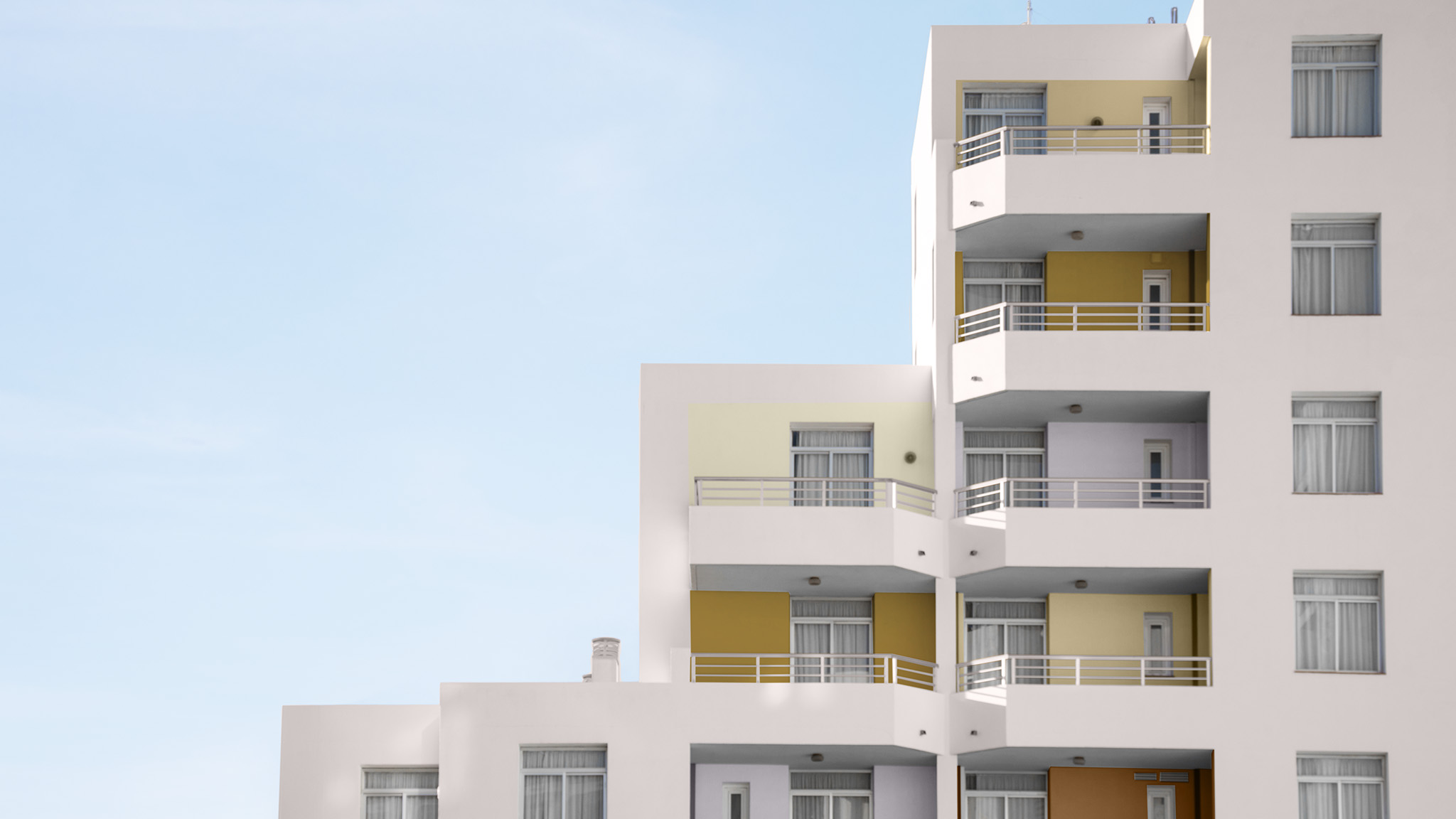 Ein abgestufter Hotelbereich in sanftem Rosa mit gelben und ockerfarbenen Akzenten