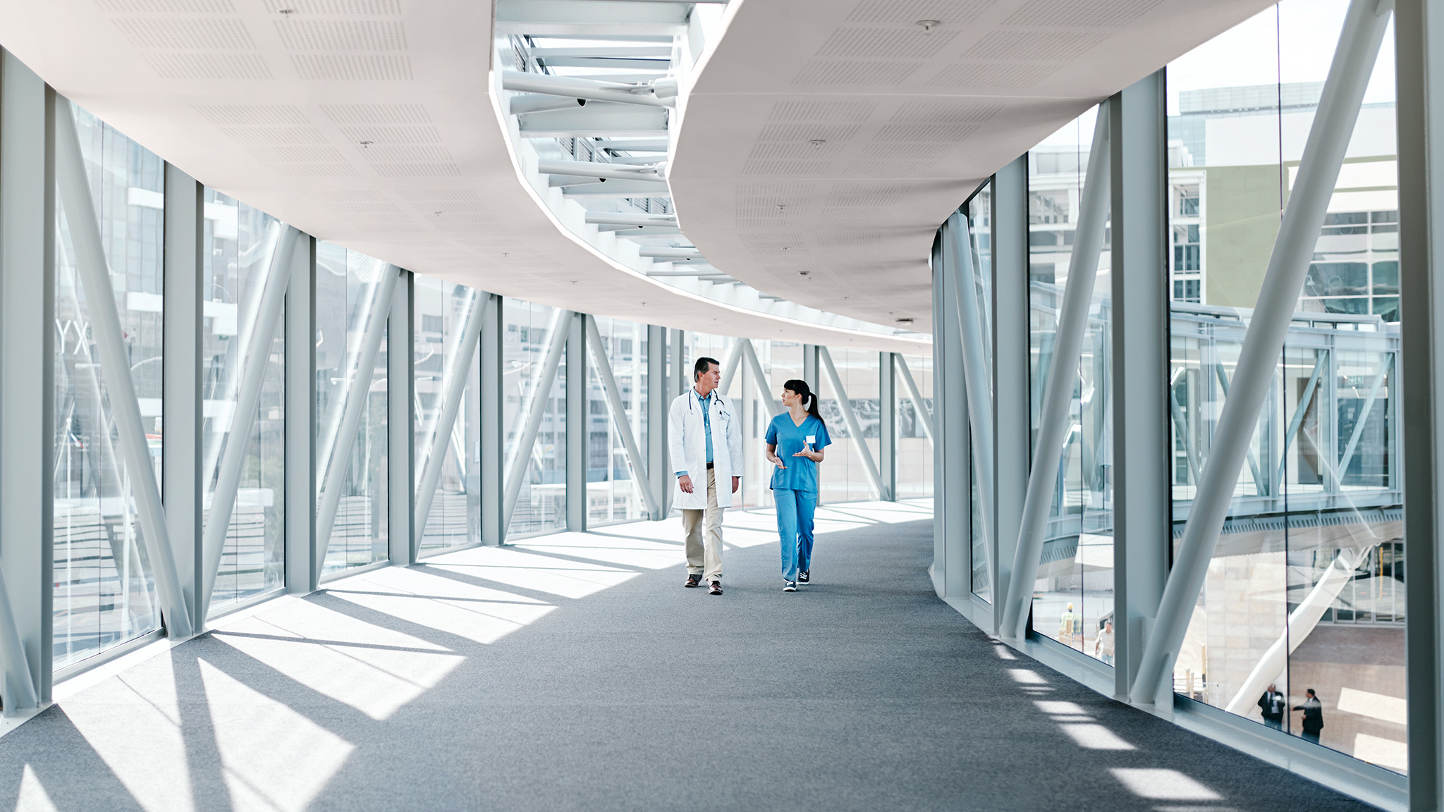 Ein Gang mit einer vom Boden bis zur Decke reichenden Verglasung und einer in sanftem Rosa gestrichenen Decke