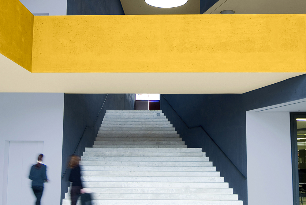 Grand entrance staircase with blue walls and yellow ceiling. 