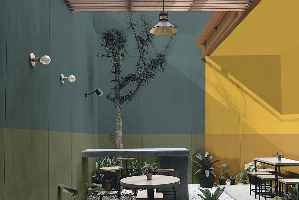 A restaurant patio area with green and blue walls on the left handside and yellow walls on the right 