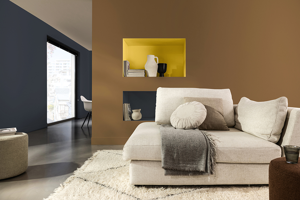 Dark brown wall with yellow accent and a white sofa