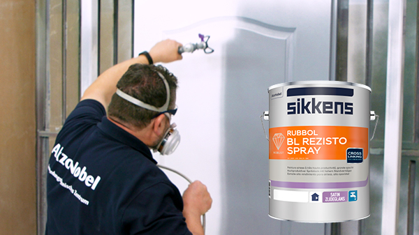 Maler spritzt eine Tür mit Lack + Lackdose