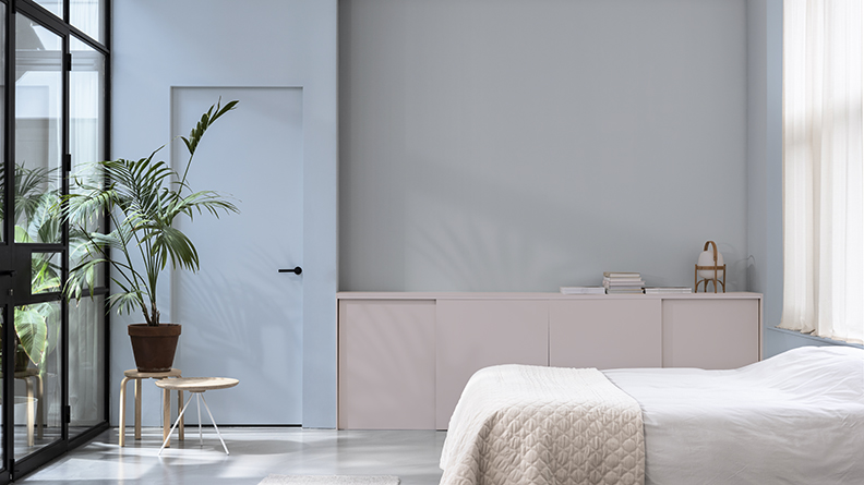 Schlafzimmer mit blauer Tür und rosa Schrank